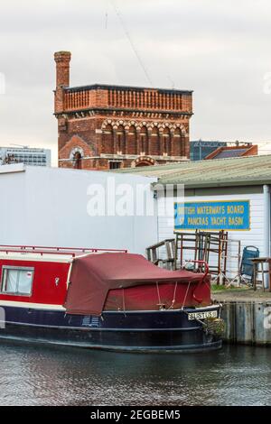 Une barque rouge amarrée dans le bassin de plaisance de St. Pancras, la tour d'eau victorienne en arrière-plan, King's Cross, Londres, Royaume-Uni Banque D'Images