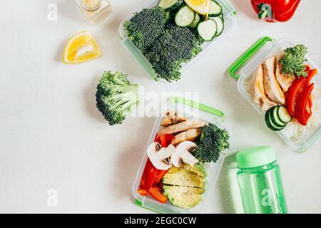 vue de dessus des légumes, du riz, de la viande dans des bols en plastique sur fond blanc clair Banque D'Images