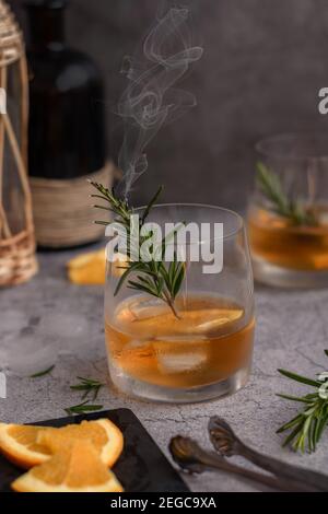 Boisson alcoolisée avec tranches d'orange et de romarin à la vapeur Banque D'Images