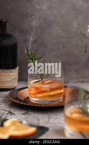 Boisson alcoolisée avec tranches d'orange et de romarin à la vapeur Banque D'Images