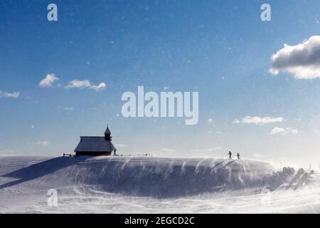 Mère et fils randonnée à la chapelle de Snow Mary dans des conditions venteuses à Velika planina pré, Slovénie Banque D'Images