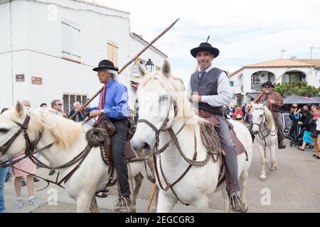 'Les Gardiens Camargaise', au sommet de leurs chevaux camarguais, approche de l'église des Saintes Marie de la Mer pour la procession à la mer. Le cavalier local Banque D'Images