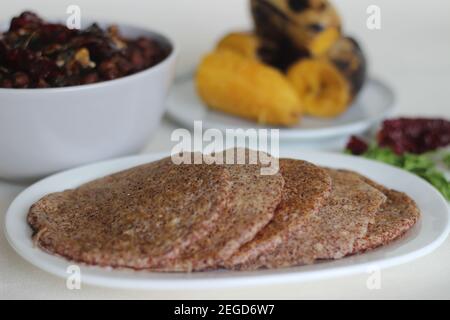 Crêpes faites maison au millet servi avec de la sauce aux pois chiches noirs et de la plantain à la vapeur. Expérimentez avec des minoteries à la maison. Photo sur fond blanc Banque D'Images