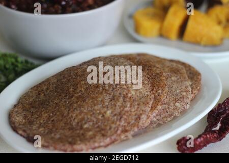 Crêpes faites maison au millet servi avec de la sauce aux pois chiches noirs et de la plantain à la vapeur. Expérimentez avec des minoteries à la maison. Photo sur fond blanc Banque D'Images
