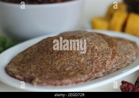 Crêpes faites maison au millet servi avec de la sauce aux pois chiches noirs et de la plantain à la vapeur. Expérimentez avec des minoteries à la maison. Photo sur fond blanc Banque D'Images