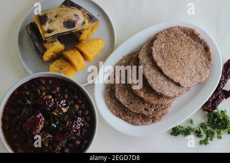 Crêpes faites maison au millet servi avec de la sauce aux pois chiches noirs et de la plantain à la vapeur. Expérimentez avec des minoteries à la maison. Photo sur fond blanc Banque D'Images