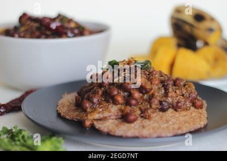 Crêpes faites maison au millet servi avec de la sauce aux pois chiches noirs et de la plantain à la vapeur. Expérimentez avec des minoteries à la maison. Photo sur fond blanc Banque D'Images