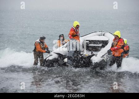 Départ touristique à l'atterrissage à St Andrews Bay sur la Géorgie du Sud L'Antarctique insulaire dans un bateau Zodiac dans la neige Banque D'Images