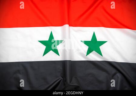 Fabrique le drapeau national de la Syrie comme toile de fond Banque D'Images