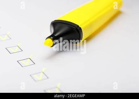 Marqueur jaune avec marqueurs sur la feuille de liste de contrôle. Concept de la tâche terminée de la liste de contrôle. Banque D'Images