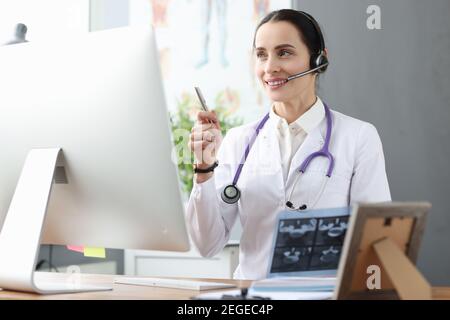 Médecin dans le casque communiquant avec le patient via la liaison vidéo Banque D'Images
