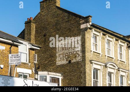 Un panneau fantôme pour Uridge's Stores sur le côté d'un bâtiment dans le centre-ville de Bromley, dans le sud de Londres. Banque D'Images