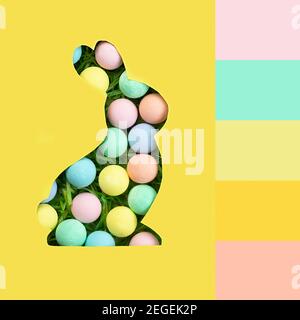 Palette de couleurs correspondant à l'image de la carte de vœux Happy Easter. Une silhouette de lapin est coupée en papier. Arrière-plan de boules multicolores en pa Banque D'Images