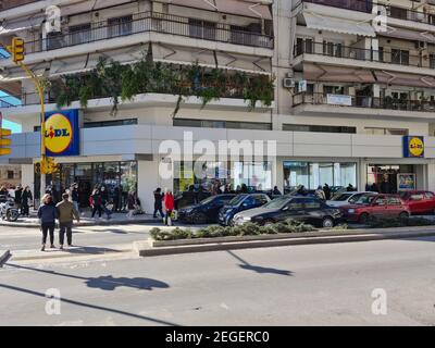 Thessalonique, Grèce février - 18 2021: Foule avec des masques Covid-19 faisant la queue en dehors du super marché. Un grand nombre de personnes avec protection du visage attendent en ligne pour entrer dans LE MAGASIN DE rabais allemand LIDL Stiftung. Banque D'Images