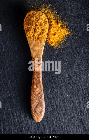 Poudre de curcuma indienne. Épice curcuma. Curcuma moulu dans une cuillère en bois. Vue de dessus. Banque D'Images