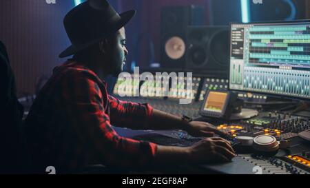 Energétique Homme Ingénieur Audio Producteur travaillant dans Music Recording Studio, mélangeant des pistes sur Control Desk et des logiciels pour créer la piste HIT Song. Artiste Banque D'Images