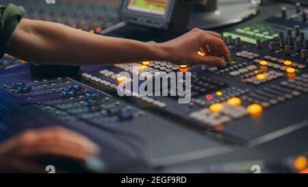 Ingénieur audio, musicien, artiste travaille dans Music Record Studio, Control Desk Mixer. Mains en contact interrupteurs, boutons, curseurs, Motorisés Banque D'Images