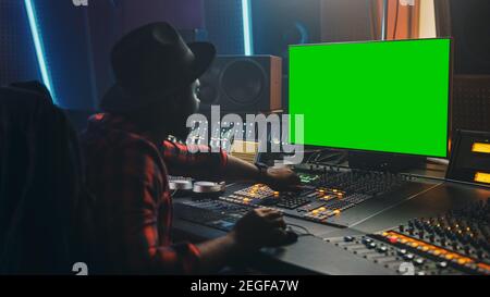 Portrait d'un producteur d'ingénieur audio élégant travaillant dans Music Record Studio, utilise un ordinateur à écran vert, un tableau de mixage, un bureau de contrôle pour créer un nouveau morceau Banque D'Images