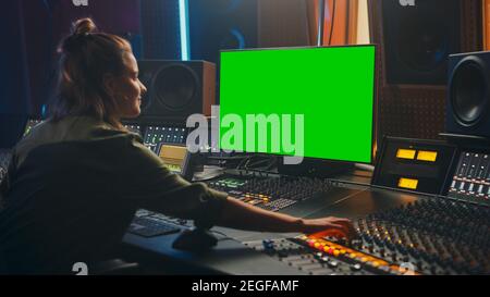 Portrait d'un producteur d'ingénieur audio féminin élégant travaillant dans Music Record Studio, utilise l'écran vert de l'écran d'affichage de l'ordinateur, le tableau de mixage, Control Desk pour Banque D'Images
