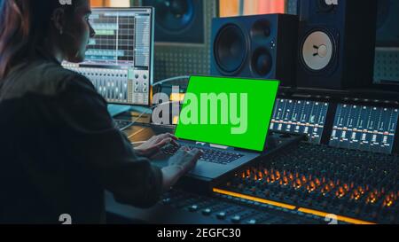 Femme artiste, musicienne, productrice, Ingénieur audio travaillant dans Music Record Studio sur un nouvel album, utiliser un ordinateur portable à écran vert, Control Desk pour Banque D'Images