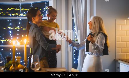 Plusieurs générations de belles femmes se préparant et dansant dans la cuisine. Grand-mère, fille et petite-fille mignonne ont l'amusement, la cuisine Banque D'Images