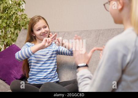 deux filles sourdes qui parlent des gestes sur le canapé. de haute qualité Banque D'Images