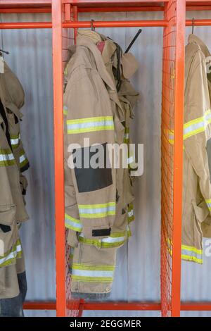 Plan vertical d'un porte-vêtements en métal avec uniformes de pompier une station Banque D'Images