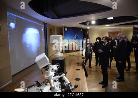 Le président français Emmanuel Macron (C) examine un modèle 3D de l'instrument SuperCam exposé au Centre national français d'études spatiales (CNES) lors d'une visite pour assister à l'atterrissage de la persévérance de la NASA Mars rover sur la planète Mars, à Paris le 18 février 2021. Le rover d'exploration de Mars recherchera des signes de vie microbienne ancienne et recueillera des échantillons de roche pour un retour futur sur Terre afin d'étudier la géologie et le climat de la planète rouge, ouvrant la voie à l'exploration humaine. La persévérance porte également l'hélicoptère expérimental Ingenuity Mars - qui va tenter le premier puissant, controll Banque D'Images