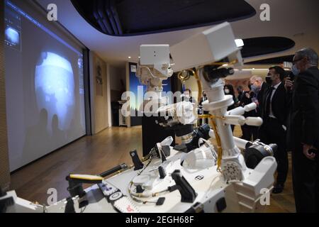 Le président français Emmanuel Macron (C) examine un modèle 3D de l'instrument SuperCam exposé au Centre national français d'études spatiales (CNES) lors d'une visite pour assister à l'atterrissage de la persévérance de la NASA Mars rover sur la planète Mars, à Paris le 18 février 2021. Le rover d'exploration de Mars recherchera des signes de vie microbienne ancienne et recueillera des échantillons de roche pour un retour futur sur Terre afin d'étudier la géologie et le climat de la planète rouge, ouvrant la voie à l'exploration humaine. La persévérance porte également l'hélicoptère expérimental Ingenuity Mars - qui va tenter le premier puissant, controll Banque D'Images