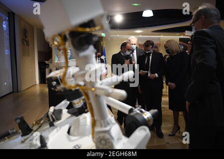 Le président français Emmanuel Macron (C) examine un modèle 3D de l'instrument SuperCam exposé au Centre national français d'études spatiales (CNES) lors d'une visite pour assister à l'atterrissage de la persévérance de la NASA Mars rover sur la planète Mars, à Paris le 18 février 2021. Le rover d'exploration de Mars recherchera des signes de vie microbienne ancienne et recueillera des échantillons de roche pour un retour futur sur Terre afin d'étudier la géologie et le climat de la planète rouge, ouvrant la voie à l'exploration humaine. La persévérance porte également l'hélicoptère expérimental Ingenuity Mars - qui va tenter le premier puissant, controll Banque D'Images