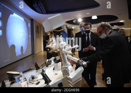 Le président français Emmanuel Macron (C) examine un modèle 3D de l'instrument SuperCam exposé au Centre national français d'études spatiales (CNES) lors d'une visite pour assister à l'atterrissage de la persévérance de la NASA Mars rover sur la planète Mars, à Paris le 18 février 2021. Le rover d'exploration de Mars recherchera des signes de vie microbienne ancienne et recueillera des échantillons de roche pour un retour futur sur Terre afin d'étudier la géologie et le climat de la planète rouge, ouvrant la voie à l'exploration humaine. La persévérance porte également l'hélicoptère expérimental Ingenuity Mars - qui va tenter le premier puissant, controll Banque D'Images