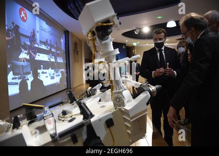 Le président français Emmanuel Macron (C) examine un modèle 3D de l'instrument SuperCam exposé au Centre national français d'études spatiales (CNES) lors d'une visite pour assister à l'atterrissage de la persévérance de la NASA Mars rover sur la planète Mars, à Paris le 18 février 2021. Le rover d'exploration de Mars recherchera des signes de vie microbienne ancienne et recueillera des échantillons de roche pour un retour futur sur Terre afin d'étudier la géologie et le climat de la planète rouge, ouvrant la voie à l'exploration humaine. La persévérance porte également l'hélicoptère expérimental Ingenuity Mars - qui va tenter le premier puissant, controll Banque D'Images