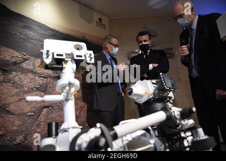 Le président français Emmanuel Macron (C) examine un modèle 3D de l'instrument SuperCam exposé au Centre national français d'études spatiales (CNES) lors d'une visite pour assister à l'atterrissage de la persévérance de la NASA Mars rover sur la planète Mars, à Paris le 18 février 2021. Le rover d'exploration de Mars recherchera des signes de vie microbienne ancienne et recueillera des échantillons de roche pour un retour futur sur Terre afin d'étudier la géologie et le climat de la planète rouge, ouvrant la voie à l'exploration humaine. La persévérance porte également l'hélicoptère expérimental Ingenuity Mars - qui va tenter le premier puissant, controll Banque D'Images