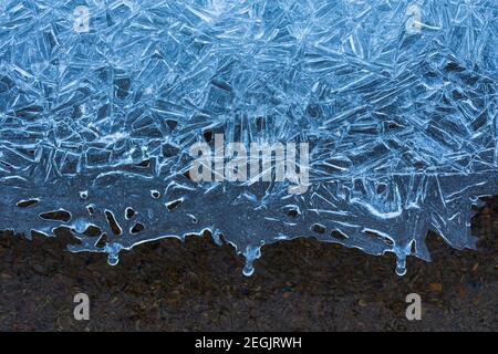 Motifs uniques formés dans la glace, avec une couche gelée au-dessus de l'eau courante claire d'East Plum Creek, Castle Rock Colorado USA. Photo prise en février. Banque D'Images