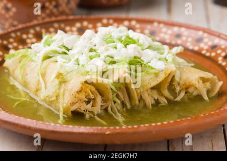 Enchiladas de poulet vert mexicain servi sur une assiette en argile traditionnelle Banque D'Images