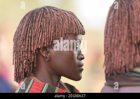 Portrait d'une femme de la tribu Banna assistant à une cérémonie de saut à la taureau. La cérémonie de saut à la taureau est un rite de passage masculin où un jeune homme cros Banque D'Images