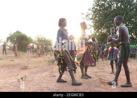 Femmes de la tribu Banna avec le jeune homme participant à la cérémonie de saut à la taureau. La cérémonie de saut à la taureau est un rite de passage masculin où un Banque D'Images