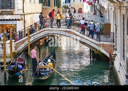 Touristes prenant la gondole, le bateau vénitien traditionnel, sur le canal à Venise, Italie Banque D'Images