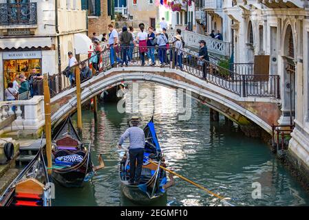 Touristes prenant la gondole, le bateau vénitien traditionnel, sur le canal à Venise, Italie Banque D'Images