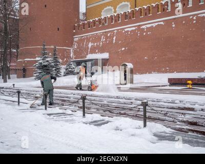 Moscou. Russie. 12 février 2021. Les employés des services publics retirent la neige à l'aide d'un souffleur à neige et de pelles lors d'une chute de neige près du mur du Kremlin, à la tombe de Banque D'Images