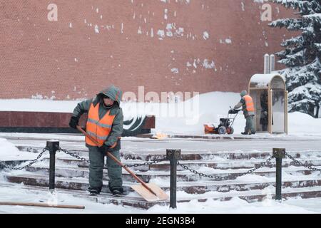 Moscou. Russie. 12 février 2021. Les employés des services publics retirent la neige à l'aide d'un souffleur à neige et de pelles lors d'une chute de neige près du mur du Kremlin, à la tombe de Banque D'Images