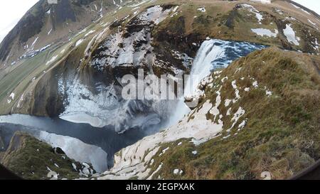 La cascade de Skogafoss vue d'en haut, la glace et la neige couvrent les parois des falaises, et la brume dans l'air Banque D'Images