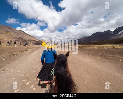 Pérou, Vinicunca - 1 octobre 2019 - les Indiens de la région transportent des touristes vers le haut et le bas de la montagne arc-en-ciel sur des chevaux Banque D'Images