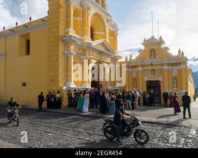 Guatemala, Antigua - 26 mai 2019 - mariage devant une vieille église, les gens se rassemblent devant un bâtiment aux murs jaunes Banque D'Images