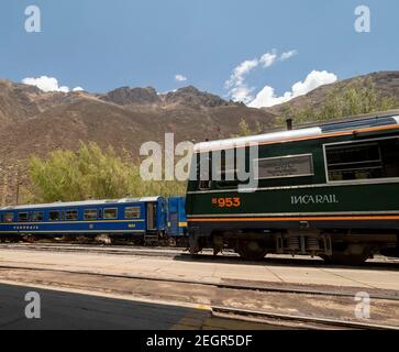 Pérou, Machupicchu - 25 septembre 2019 - trains Perurail et Incarail à la gare d'Ollantaytambo, chaîne de montagnes en arrière-plan Banque D'Images