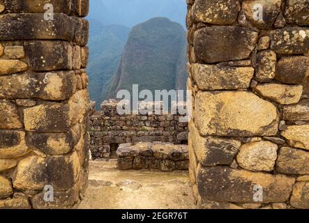 Pic de montagne vu de derrière les murs en pierre de Machu Picchu Banque D'Images