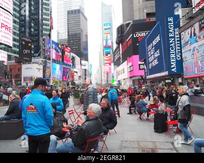 Manhattan, New York - 21 avril 2017 - Times Square affiche des publicités colorées par temps brumeux, tandis que les touristes apprécient la journée Banque D'Images