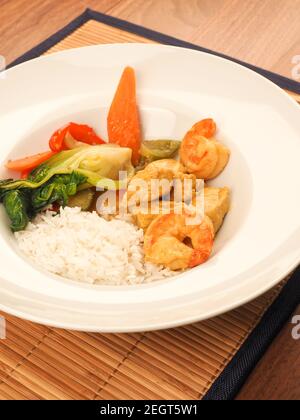 Curry thaï rouge avec poulet et crevettes avec légumes frits et riz, concept alimentaire sain Banque D'Images