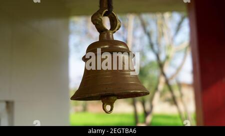 Cloche en bronze pour un son puissant. Cloche en laiton à la main dans le temple avec un arrière-plan flou. Banque D'Images