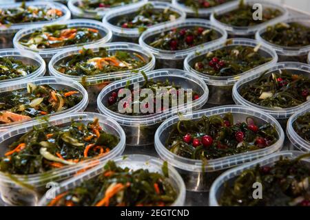 Différentes salades d'algues de poisson et de chuka wakame laminaria en plastique bowles. Concept de production ou de livraison de nourriture saine Banque D'Images